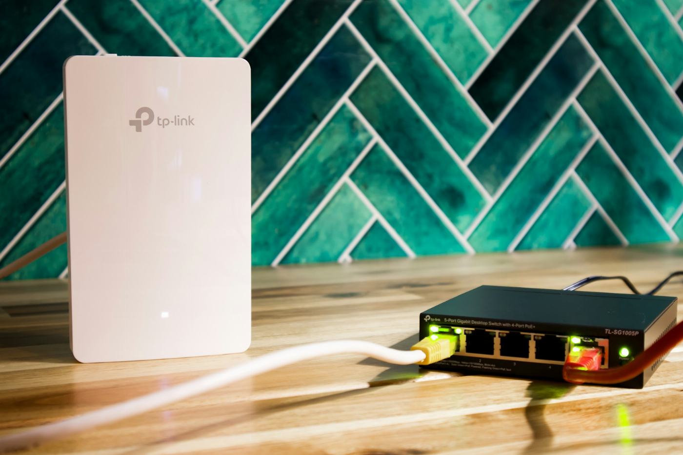 A WiFi access point and a network switch on a wooden desk